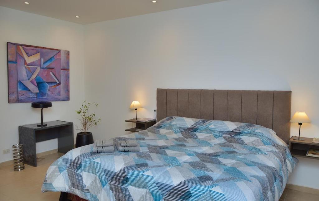 a bedroom with a bed with a colorful comforter at Hermoso departamento entero 2 Dormitorios con cochera B Urca in Cordoba