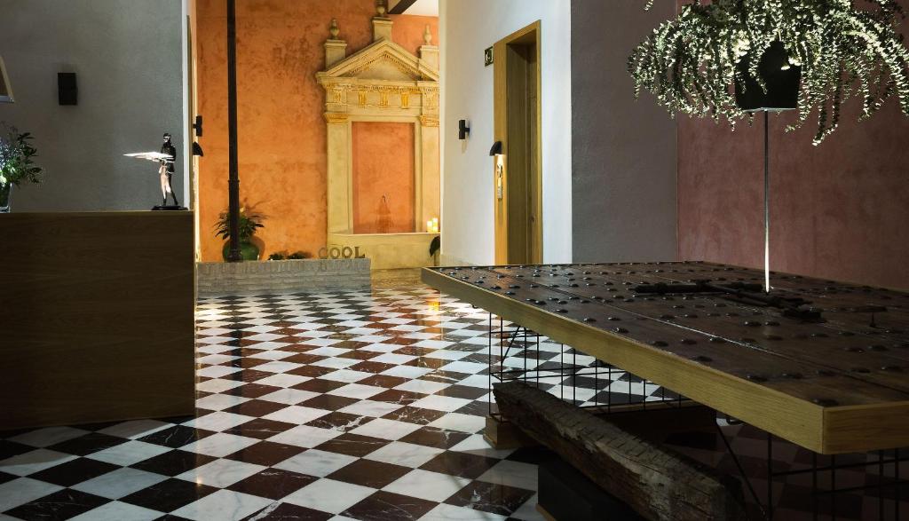 a dining room with a table and a checkered floor at Aguilas5 SevillaSuites in Seville