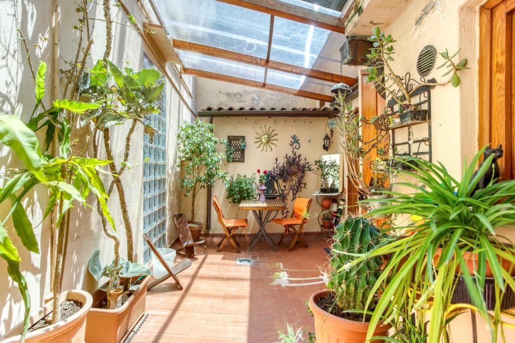 an indoor greenhouse with plants and a table and chairs at Maggiore 145 apartment with private garden - Rione Monti in Rome