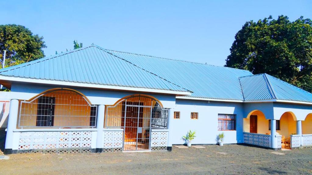a white and blue house with a blue roof at Osotwa Maasai Hostel in Arusha