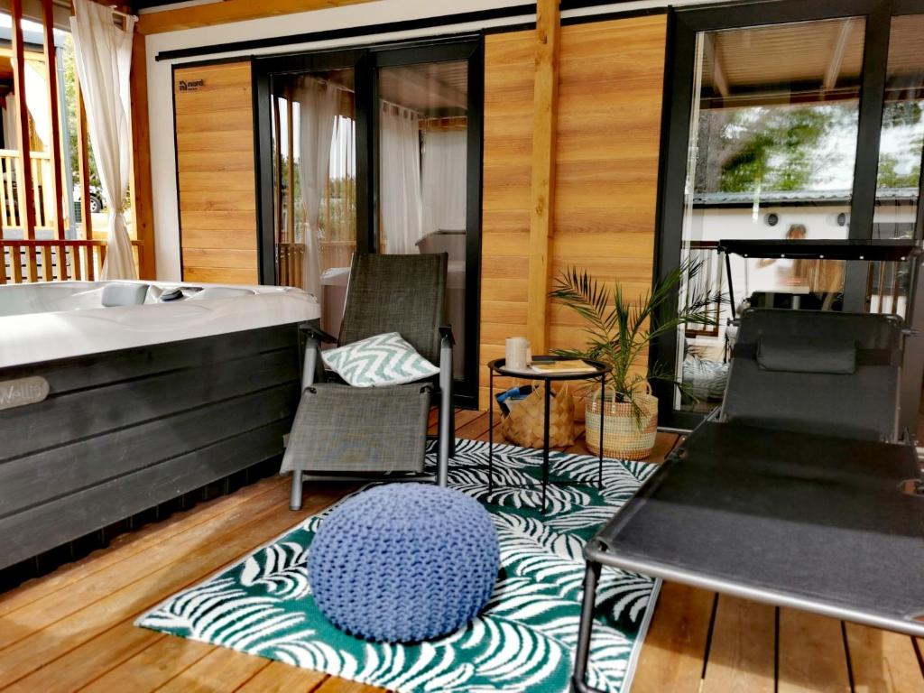 ein Badezimmer mit einer Badewanne und zwei Stühlen auf einem Teppich in der Unterkunft Mobile Home Aurora Selce in Selce