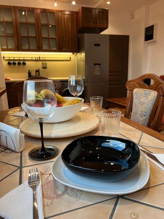 a table with a black plate and wine glasses on it at Dalv Residence - SPA Fairy Tale in old Sofia in Sofia
