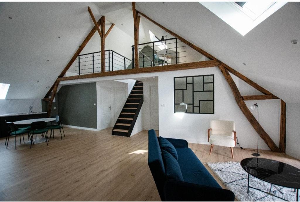 a living room with a staircase in a loft at Petit Nid Douillet in Solre-le-Château