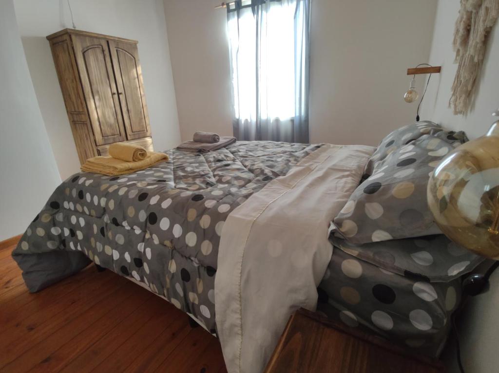 1 dormitorio con cama con colcha de lunares en Rossi, en Malargüe