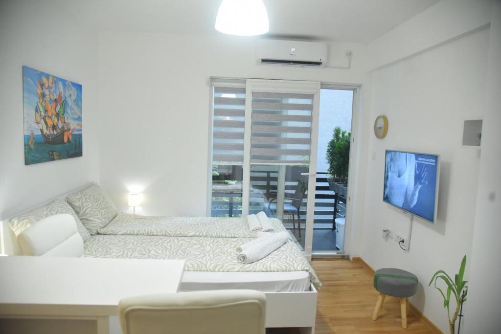 uma sala de estar branca com um sofá e uma mesa em Dekart 2 Apartment em Niš