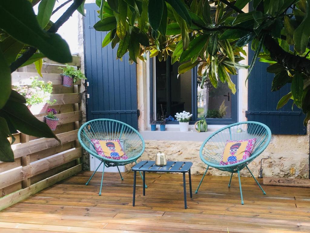 2 sillas y una mesa en el patio en La ti case - studio de charme au coeur du medoc, en Saint-Laurent-de-Médoc