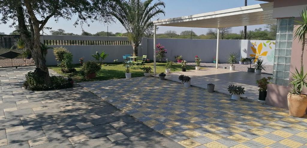 a courtyard with potted plants and a fence at Country Block in Gaborone