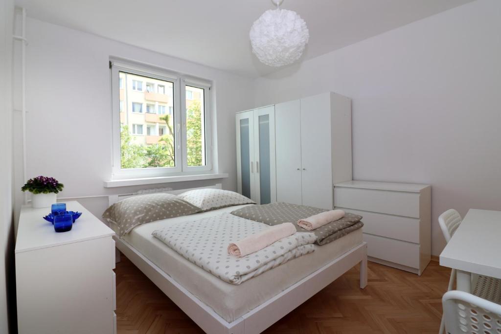 biała sypialnia z łóżkiem i oknem w obiekcie AAPARTAMENT w mieście Gdynia