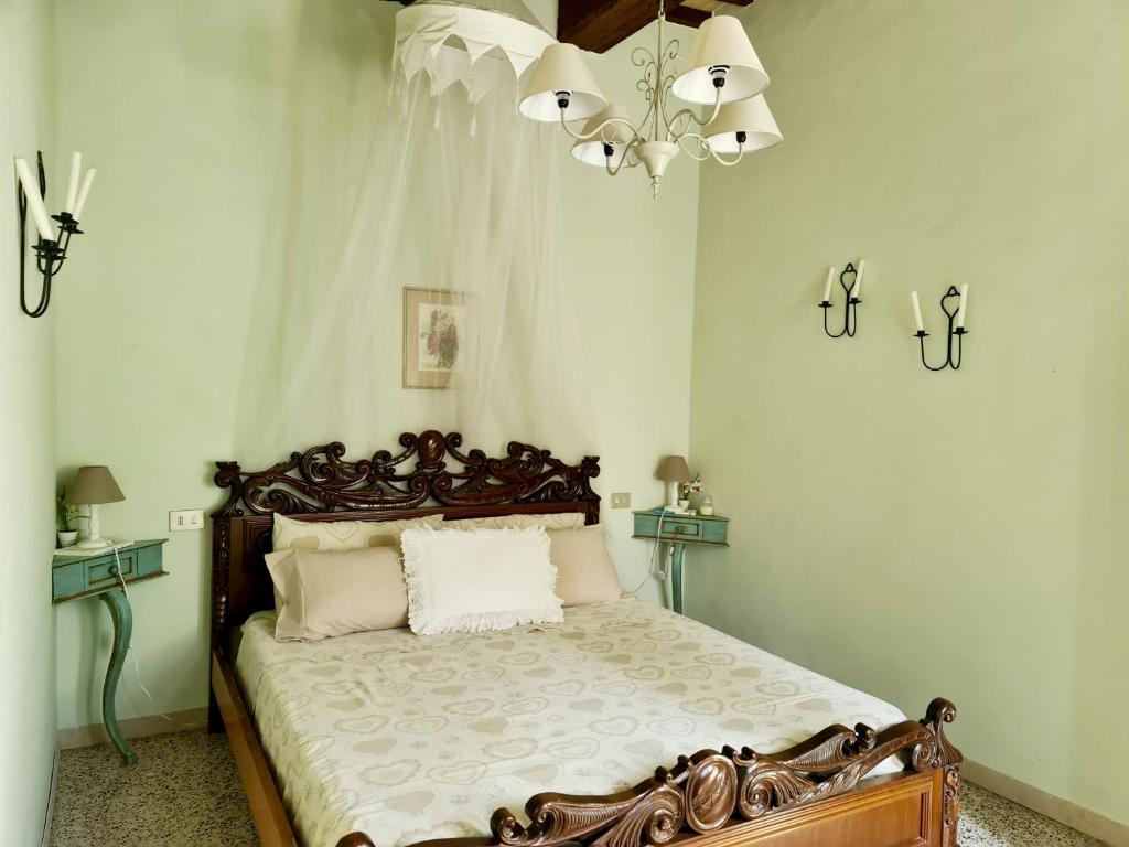 a bedroom with a bed and a chandelier at Le Rondini in Petrignano