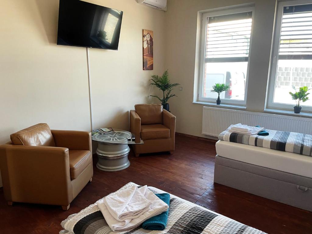 a living room with a couch and chairs and a tv at DZ Appartements - Ferienwohnung mit Klimaanlage, Whirlpool und freiem WLAN - ruhige, zentrale Lage in Wittenberge in Wittenberge