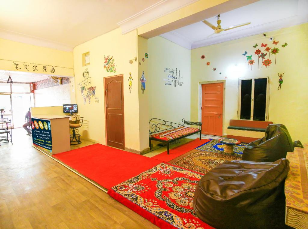 a living room with a couch and a red rug at Pink City Hostel in Jaipur