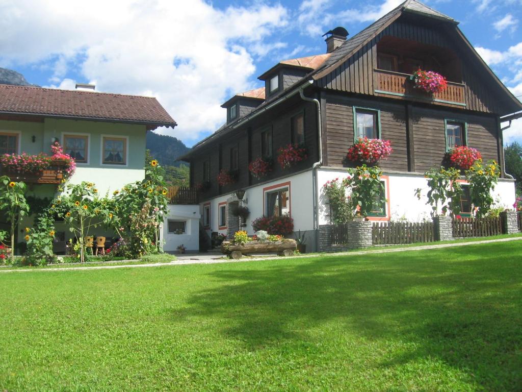 ein Haus mit grünem Rasen davor in der Unterkunft Harreiterhof in Aich