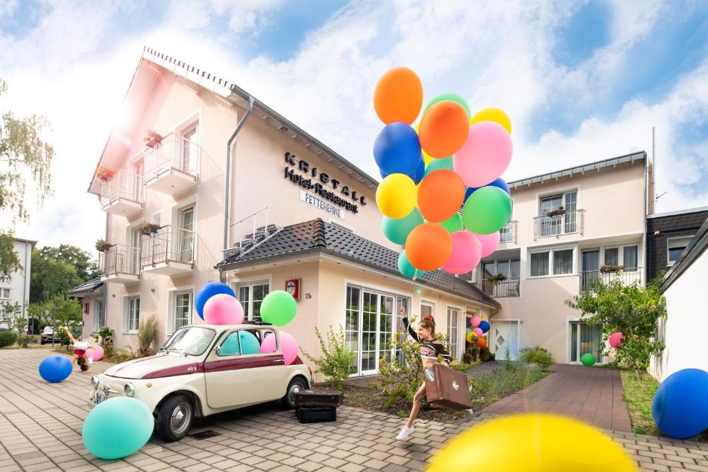 勒沃庫森的住宿－Kristallhotel Fettehenne，女人站在一辆装有气球的汽车旁边