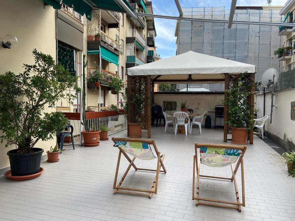 a patio with chairs and an umbrella and a table at SUNNY APARTMENT with big terrace in Rapallo