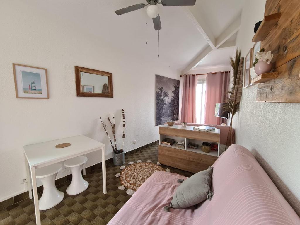 um quarto com uma cama, uma mesa e um lavatório em Le coeur des sables em Le Grau-dʼAgde
