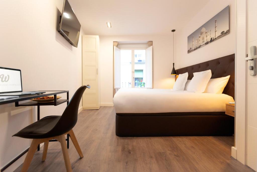 Schlafzimmer mit einem Bett, einem Schreibtisch und einem Stuhl in der Unterkunft Woohoo Rooms Hortaleza in Madrid