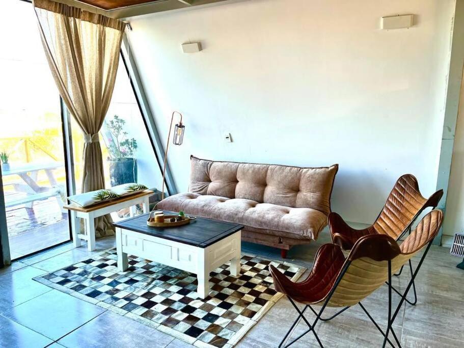 a living room with a couch and a table and chairs at Cabaña Nórdica muy cómoda para unos días de relax in Villa Serrana