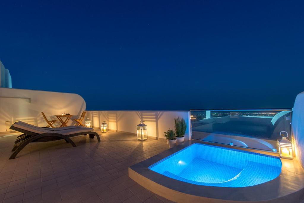 a patio with a hot tub and a couch at Anamnesis City Spa in Fira