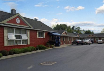 une maison en briques rouges avec des voitures garées dans un parking dans l'établissement Boulevard Inn, à Amherst