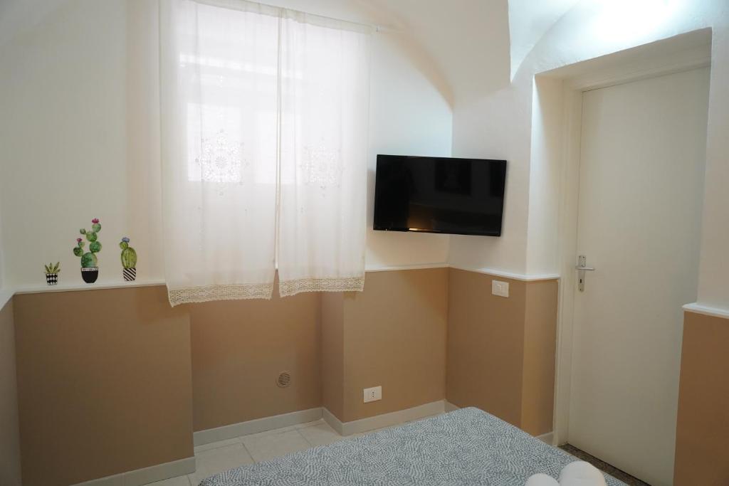 salon z telewizorem i oknem w obiekcie Sicily House Caronda Catania w Katanii