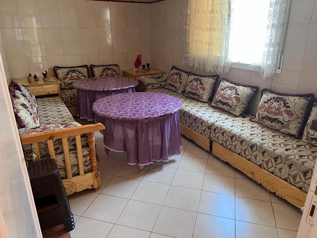 sala de estar con 2 mesas y sofá en 2 Zimmer Wohnung Corniche Nador Sidi Ali- am Meer & Wifi, en Nador