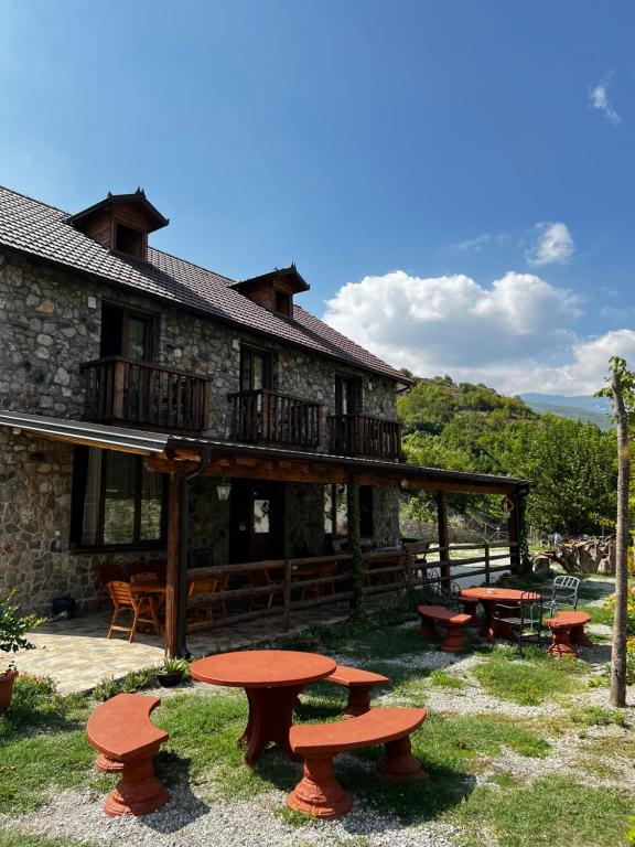 a building with picnic tables in front of it at Guest House Aprripe Guri in Fierzë