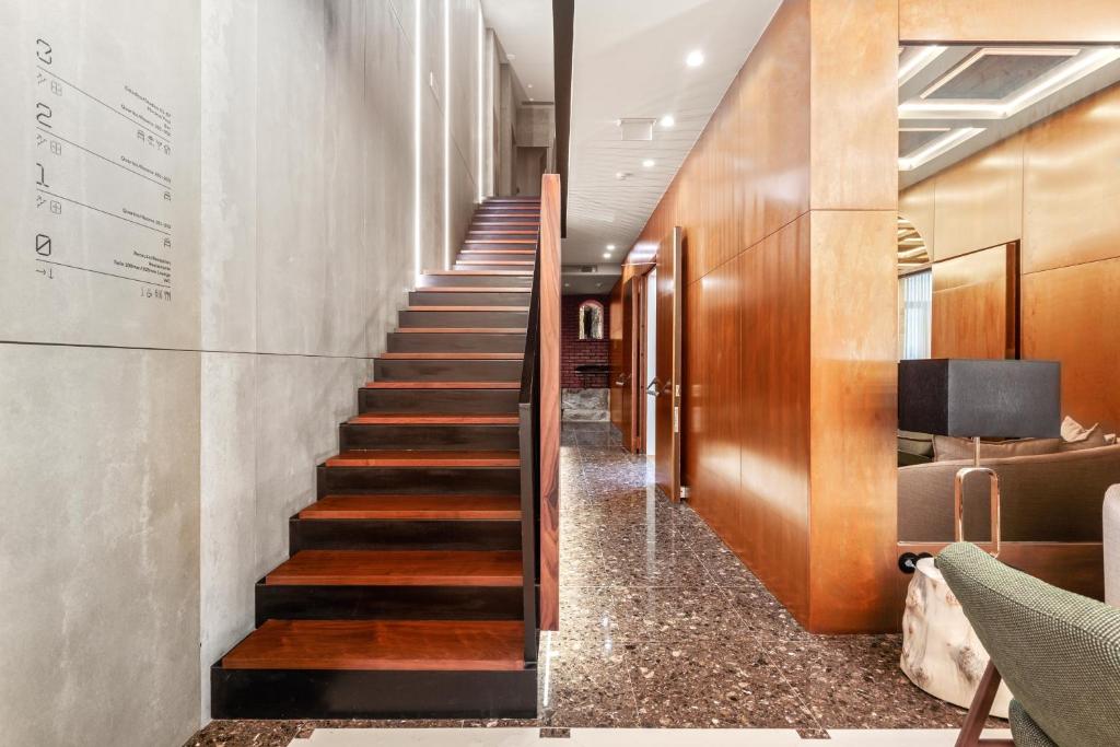a staircase in a lobby with wood and marble floors at 108MM House in Porto
