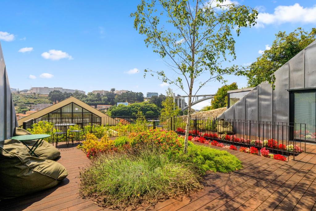 a patio with a garden with flowers and a building at 108MM House in Porto