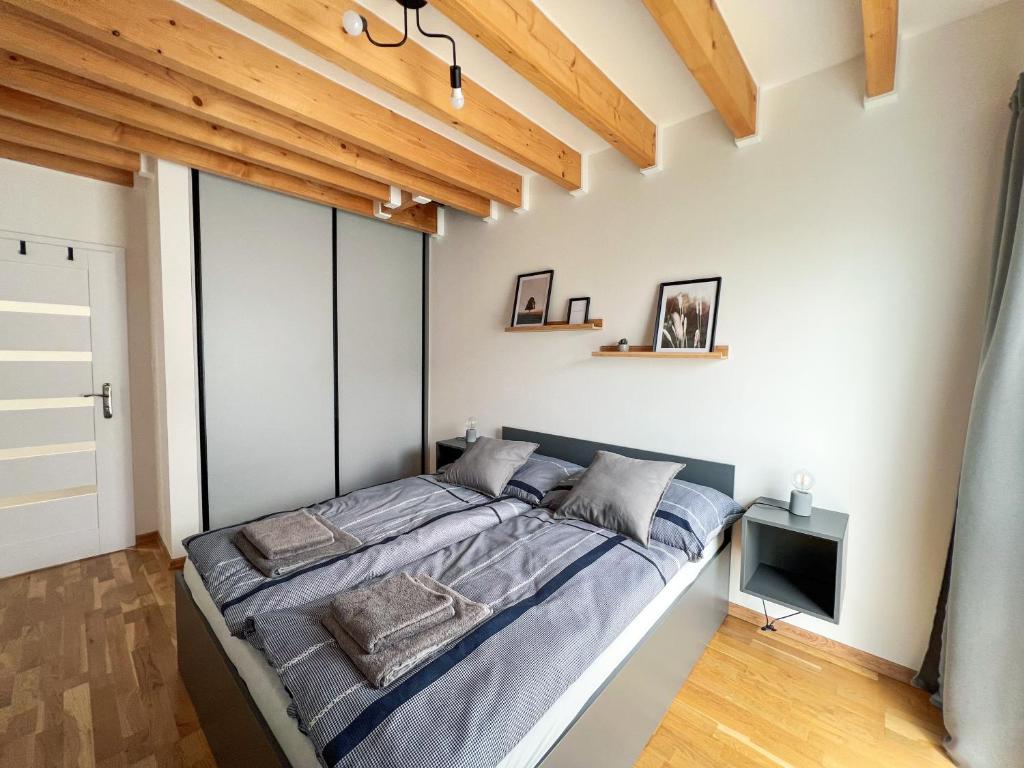 a bedroom with a large bed in a room with wooden ceilings at Holiday house DOMa Nová Lesná in Nová Lesná