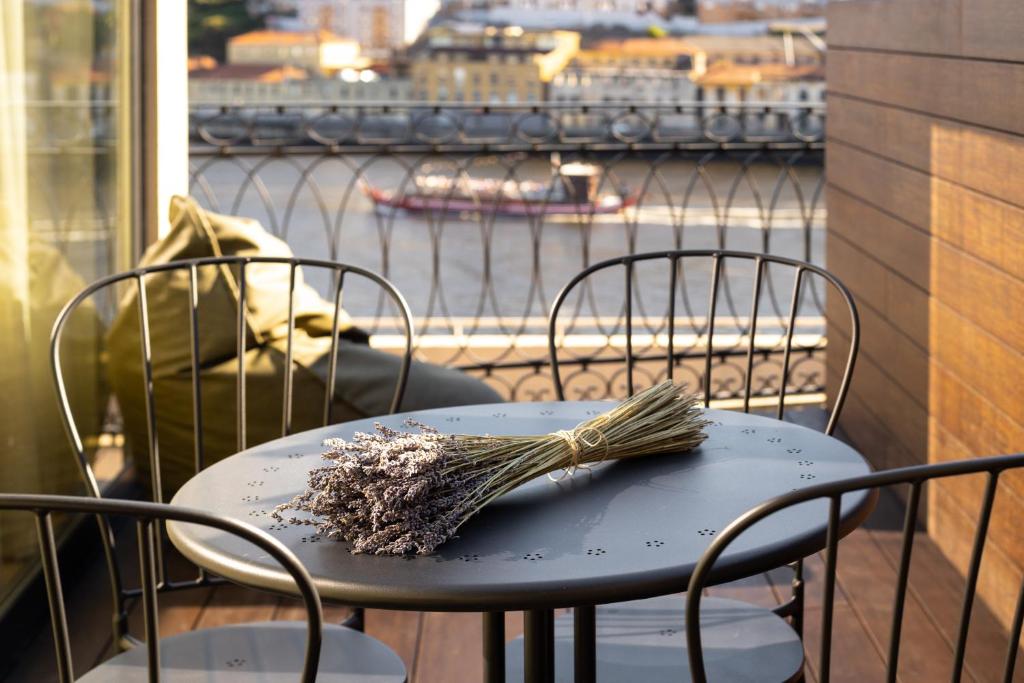 a table and chairs on a balcony with a view of a river at 108MM House in Porto