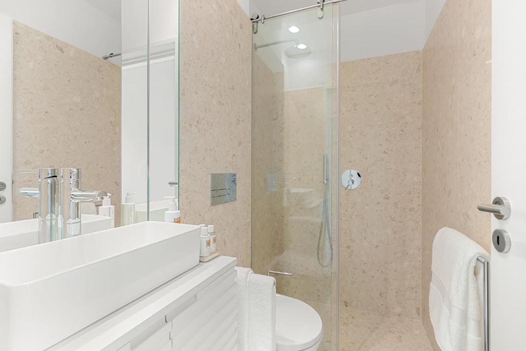 a bathroom with a toilet and a glass shower at 108MM House in Porto