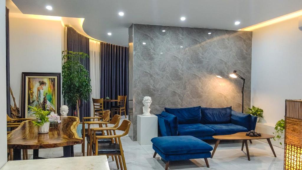 a living room with a blue couch and tables and chairs at Green Line Long Bien - Serviced Apartment - Ngoc Thuy - Hanoi in Hanoi