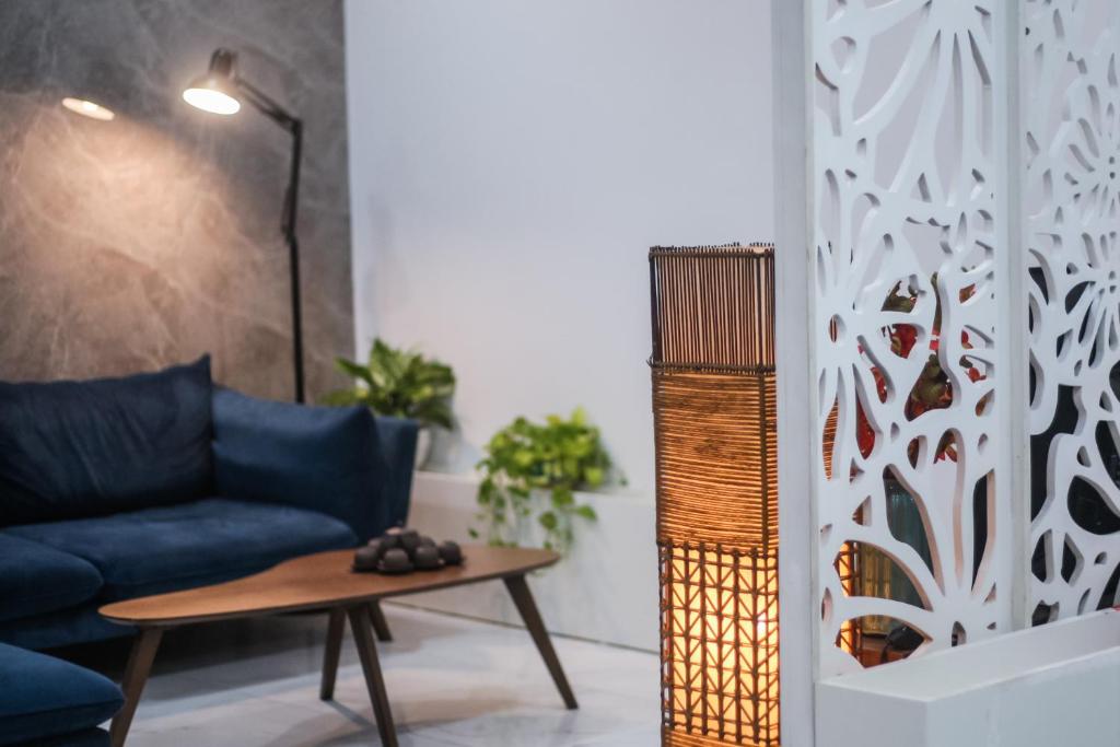 a living room with a blue couch and a table at Green Line Long Bien - Serviced Apartment - Ngoc Thuy - Hanoi in Hanoi