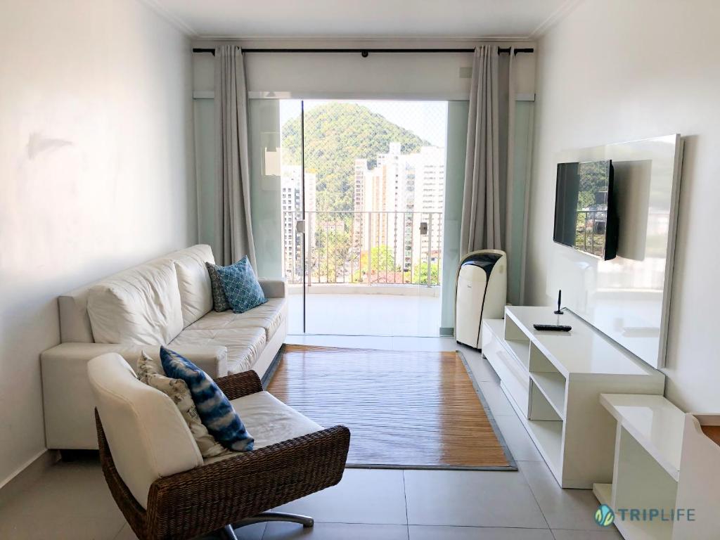 sala de estar con sofá, silla y mesa en Apartamento da Pitangueiras, en Guarujá