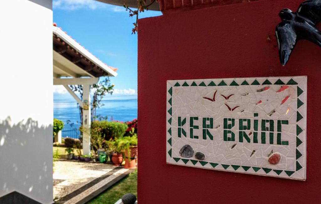 um sinal no lado de uma casa vermelha em La Chambre de Ker Briac no Funchal