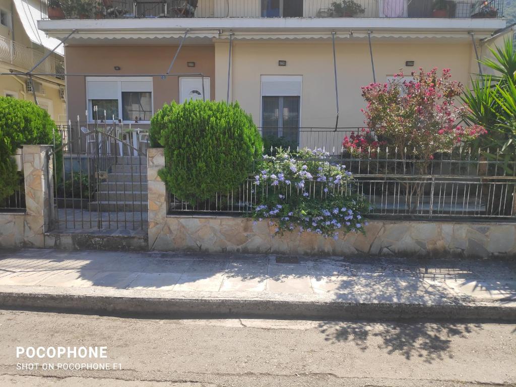 ein Haus mit Blumen vor einem Zaun in der Unterkunft Κεντρικό, ανετο και ευρύχωρο διαμέρισμα in Kamena Vourla