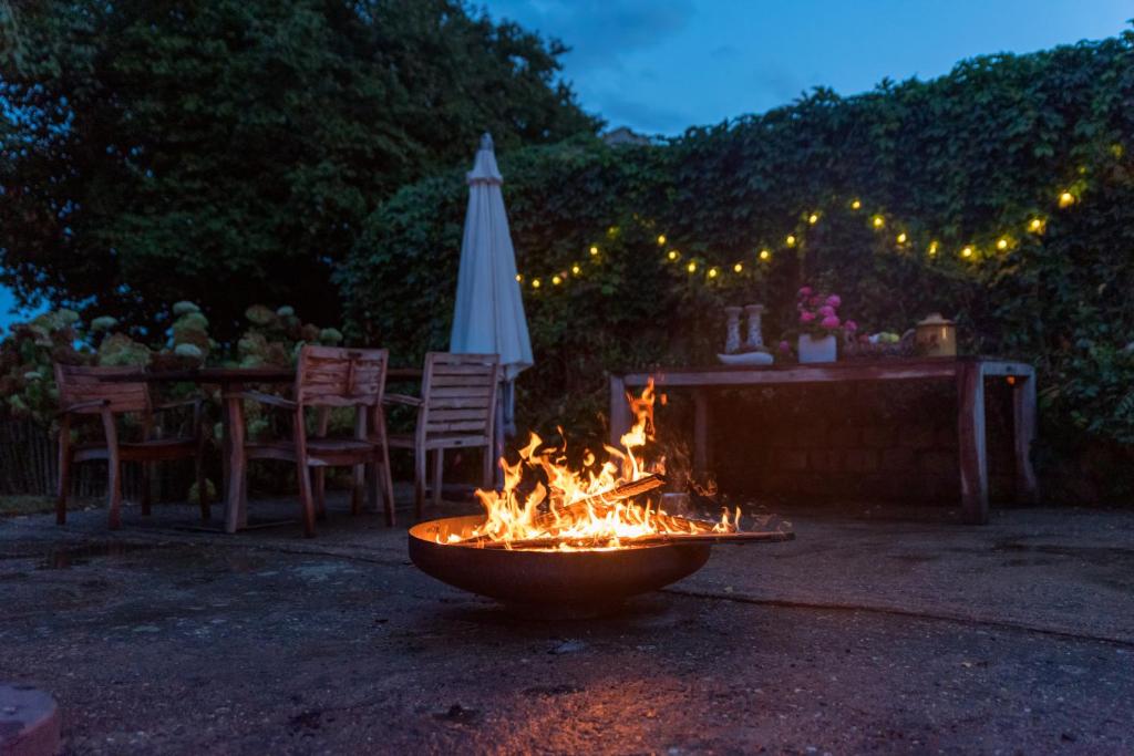a fire pit in a yard with an umbrella at Vakantiewoningen Pomona in Heers