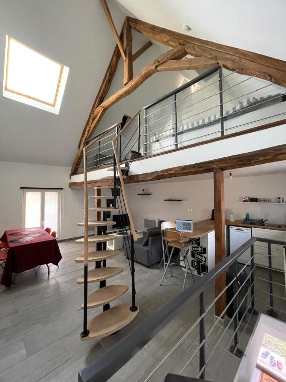 a loft conversion with a spiral staircase and a dining room at Loft Chez Guillaume in Bouleurs