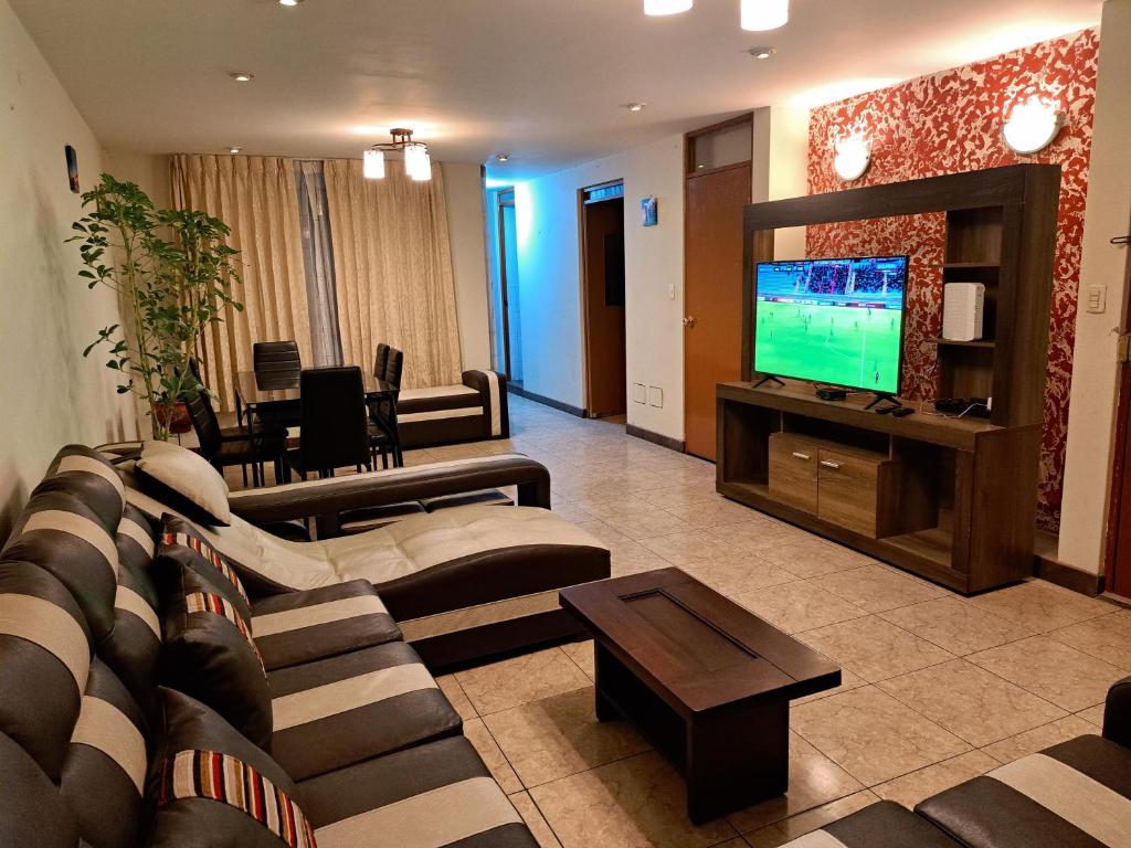 sala de estar con sofá y TV en Departamento amoblado en Arequipa, Cerro Colorado - Plaza las Américas, en La Libertad