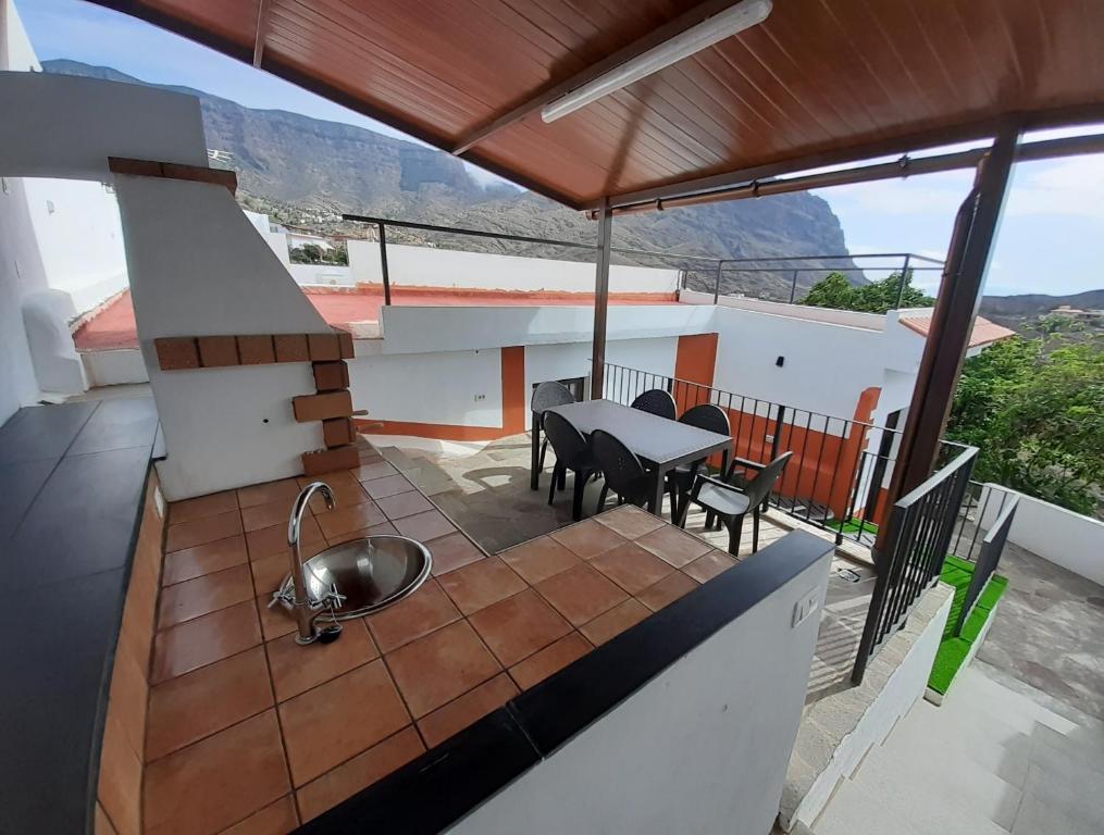 a balcony of a house with a table and chairs at Vv Puerto del Trigo - Stella in Alojera