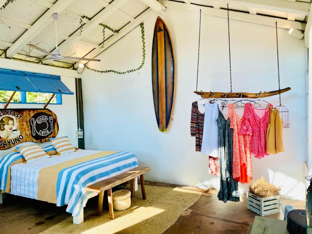 a bedroom with a bed and a surfboard on the wall at La Bocana Beach House in Santa Maria Huatulco