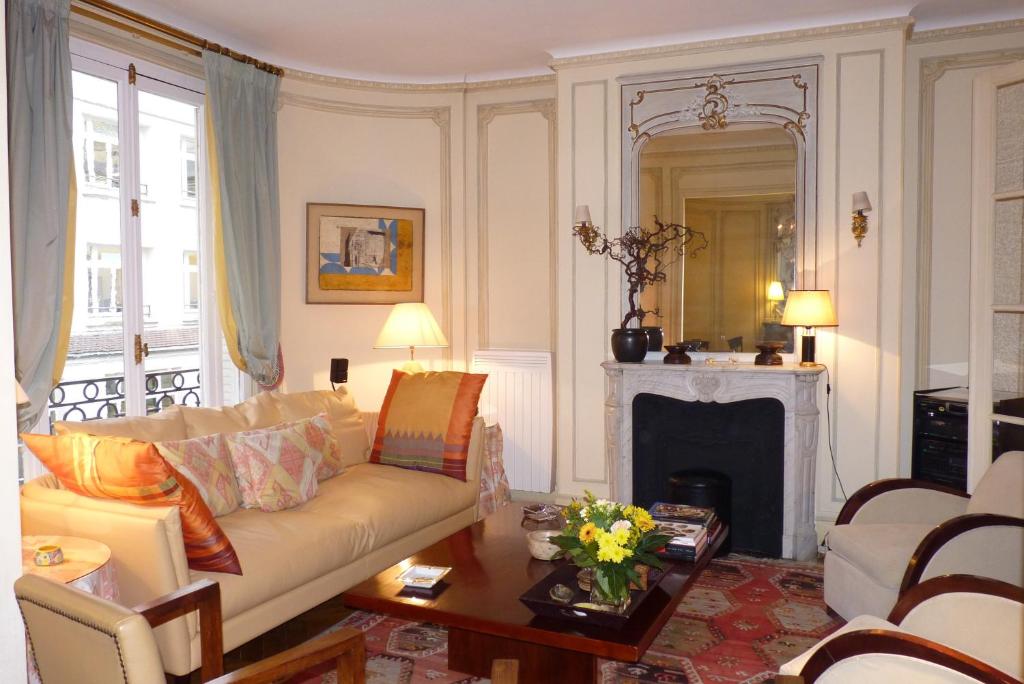 un salon avec un canapé et une cheminée dans l'établissement Prestigious 2 bedroom near Champs Elysées, à Paris