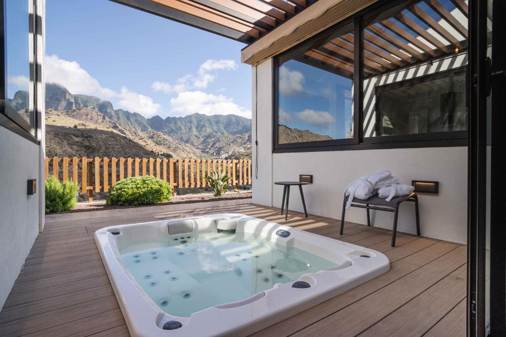 bañera de hidromasaje en una terraza con vistas a las montañas en BASÂLTO Casas Rurales, en Hermigua