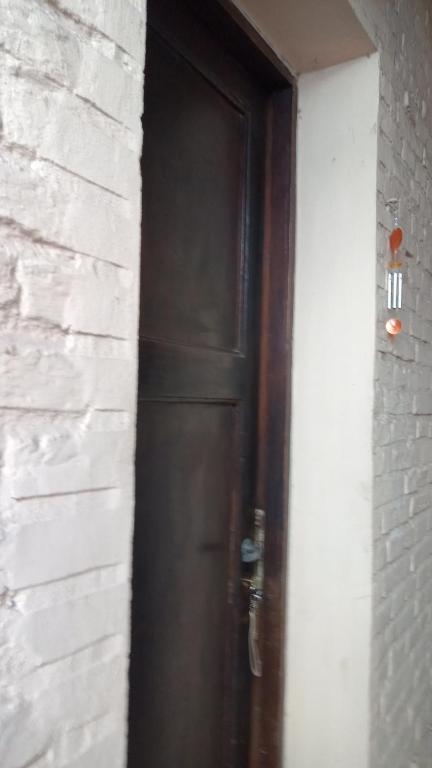 a brown door in a white brick wall at Coralca in Martínez