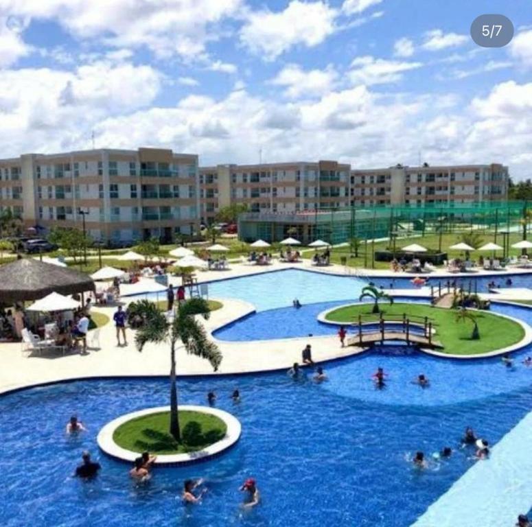 a large swimming pool with people in a resort at Flat Muro Alto Porto de Galinhas in Porto De Galinhas