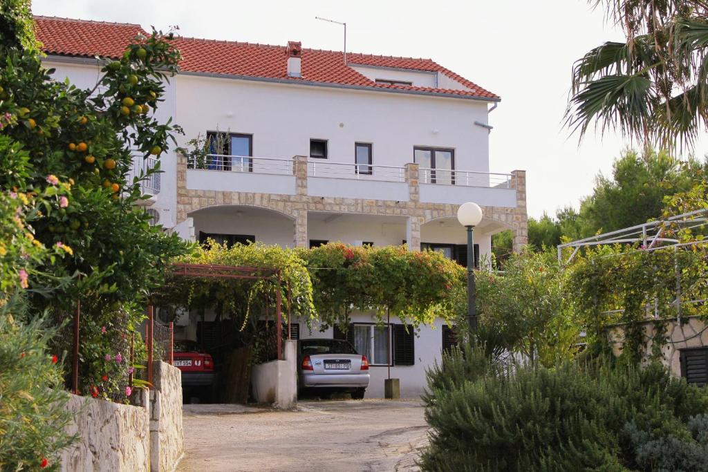 uma casa branca com um carro estacionado em frente dela em Apartments with a parking space Jelsa, Hvar - 5703 em Jelsa