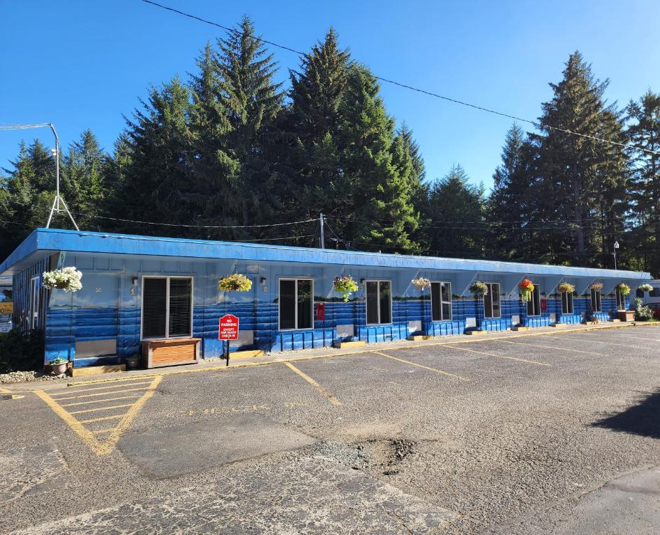a blue building with a row of windows in a parking lot at Plainview Motel in Coos Bay