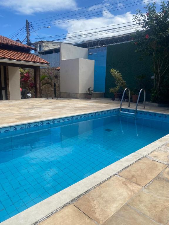 uma grande piscina com azulejos azuis num quintal em Casa com piscina cabo frio em Cabo Frio