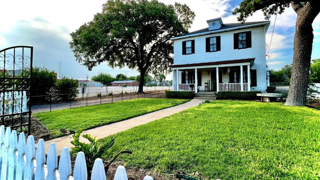 a white house with a white picket fence at Pennoli Bed and Breakfast in Gatesville
