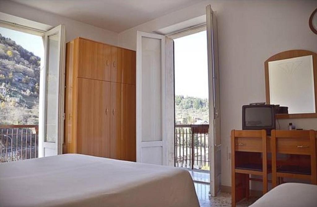 a bedroom with a bed and a balcony with a television at Hotel Margherita in Scanno